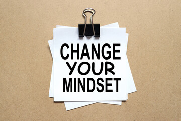 Change your mindset. the paper is clamped with a clerical clip. paper on wood background.