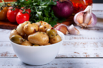 Homemade mini pickled potatoes in a white bowl. Copy space