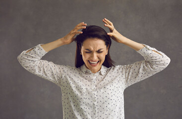 Screaming, hate, rage. Emotional angry woman in panic hysterics screams in pain and cries on the...