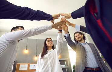 Diverse business team partners joining hands together standing in office. Teamwork and...