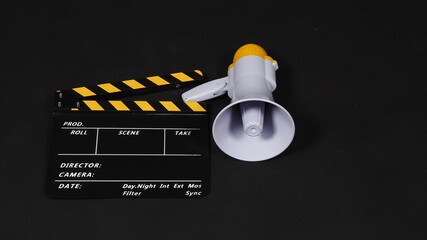 Black&yellow Clapperboard or movie clapper board and Megaphone in yellow color isolated on black...