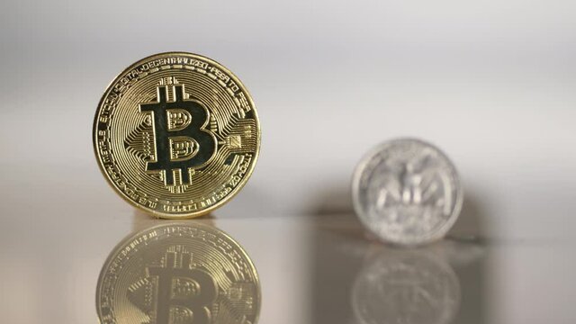 US quarter coin with Bitcoin in the background. Focus shifts from quarter to Bitcoin.	
