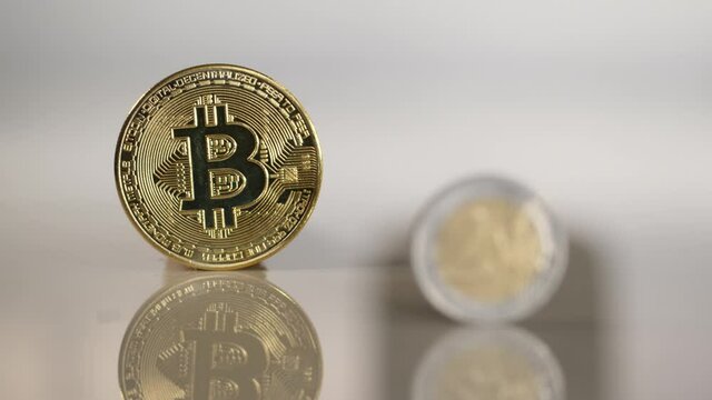 Euro coin with Bitcoin in the background. Focus shifts from euro coin to Bitcoin.	