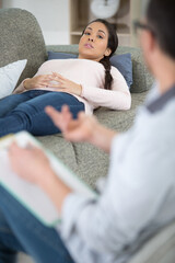 Obraz premium emotional sad woman sitting on the sofa and using gestures