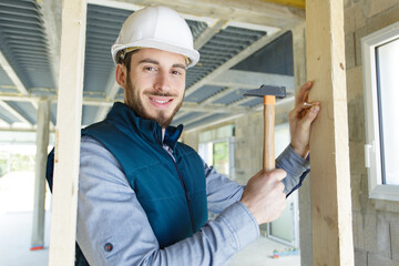 man building a house and working with hammer