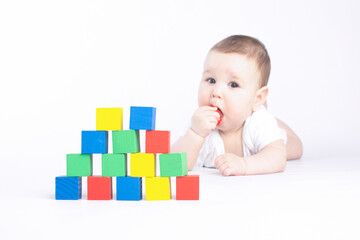 baby is played with colored cubes, on a white background