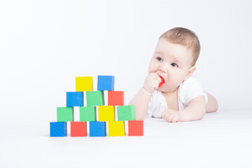 baby is played with colored cubes, on a white background