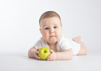 cute baby eating green apple, on white background