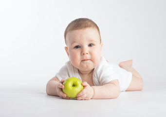 Fototapeta premium cute baby eating green apple, on white background
