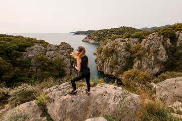 Obraz premium Rear view of attractive woman against beautiful landscape and seascape of Mediterranean Sea nature