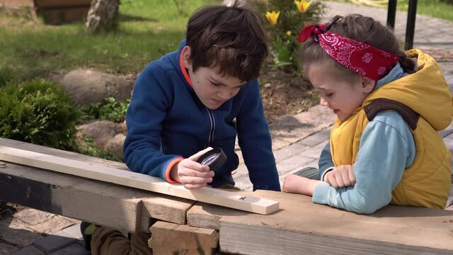 Children are doing creative work outdoors on a sunny day. Master class on wood burning or pyrography using a magnifying glass. Ideas for kids activities during the summer holidays. quality 4k footage 