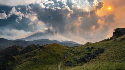 Epic skies. Magnificent panorama at sunset in the mountains with tourists in the distance. Wallpaper.