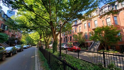 green street in the city with red buildings and trees