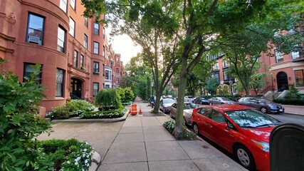 green street in the city with cars and trees