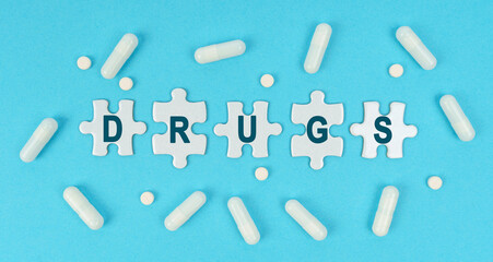 On a blue background, there are pills and puzzles with the inscription - DRUGS