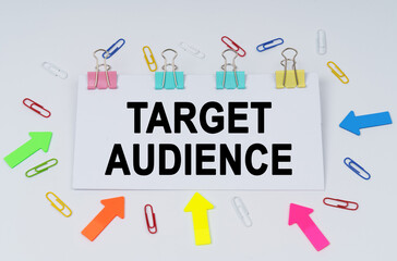 On the table there are paper clips and directional arrows, a sign that says - Target Audience