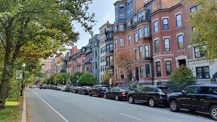 Obraz premium old town street with red buildings, park and black cars line