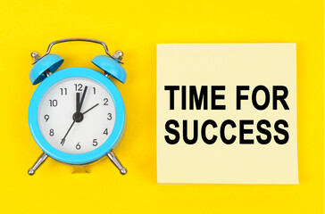 On a yellow background lie a clock and a sticker sheet with the inscription - TIME FOR SUCCESS