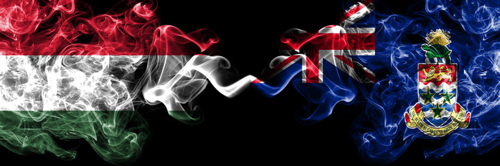 Hungary, Hungarian vs British, Britain, Cayman Islands smoky flags side by side.