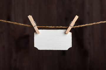 Blank wooden sign hang with clothespins on rope. Small nameplate, plate for an inscription. Copy space. Place for text.