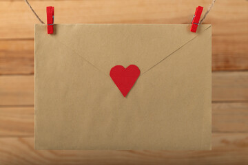 Envelope with heart hanging with clothespins on rope string peg. Letter for loved ones. Valentine's Day