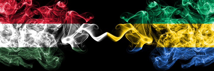 Hungary, Hungarian vs Gabon, Gabonese, Gabonian smoky flags side by side.