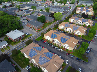 aerial view of apartment buildings with solar panel installed on roof 