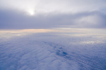 View from the window of a passenger plane during the flight. Clouds from above.