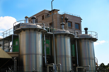 Storage tanks of dairy factory against blue sky.selective focus
