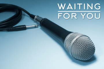 Concert microphone on a blue background with the words "waiting for you"