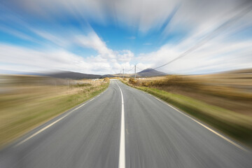 Small narrow asphalt road in Connemara, county Galway, Ireland, Warm sunny day, Travel and tourism concept. Blue cloudy sky