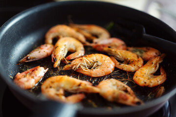 Frying shrimps with spices on skillet