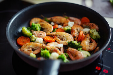 Cooking vegetables and shrimps on pan