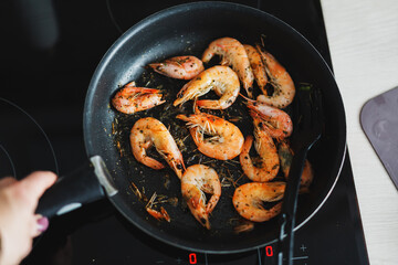 Frying shrimps with spices on skillet