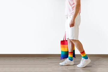 Unrecognizable young man posing dressed in socks and rainbow bag. Concept of freedom, LGBTQ+