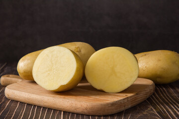 Raw potatoes on wood background