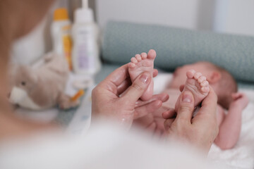 Füße von einem Neugeborenem Baby am Wickeltisch, bekommt eine Babymassage