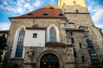 Stone medieval gothic church St. Henry and St. Kunhuty at sunny day, high tower, stone statues, stained glass windows, arched portal, arches, entrance, Prague, Czech Republic