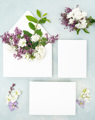 Fototapeta na wymiar Fresh lilac flower and blank stationery card flat lay