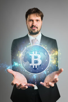 businessman presenting a hologram with a bitcoin symbol on grey background