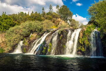 Fototapeta premium Spectacular waterfall of Poço da Broca in Barriosa, municipality of Seia in Portugal, in the Serra da Estrela Natural Park, seen from the waterline at its base.