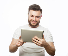 young bearded man wearing white t-shirt using a tablet computer