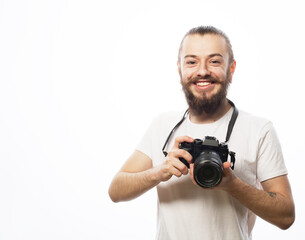 Fototapeta premium Fashion, trhnology and people concept: Young bearded photographer taking pictures with digital camera