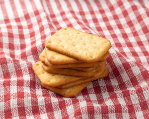 Cracker cookies with tablecloth on white wooden table background.