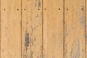 Fototapeta na wymiar 茶色い塗料の剥げかかり下地の見える板壁と釘の頭、背景素材