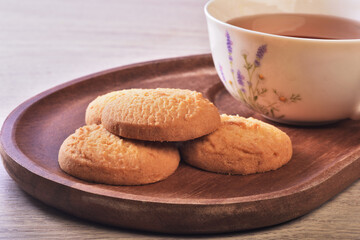 Close up of coconut cookies with tea on the wooden tray