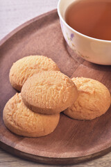 Close up of coconut cookies with tea on the wooden tray