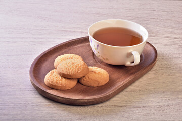 Coconut cookies with tea on the wooden tray 