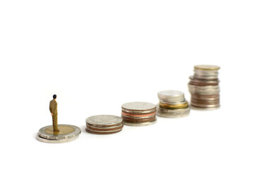 Miniature figures businessman stand on coins, on the white backgroud.