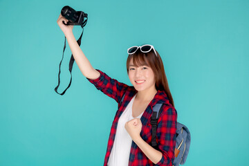 Beautiful young asian woman cheerful and enjoy travel trip summer isolated on blue background, asia girl having activity hobby take a photo holding camera, tourist journey in vacation and holiday.